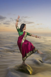 Anu Bhatt in sari dancing on a rock in the Pacific Ocean. Janvi Photography.