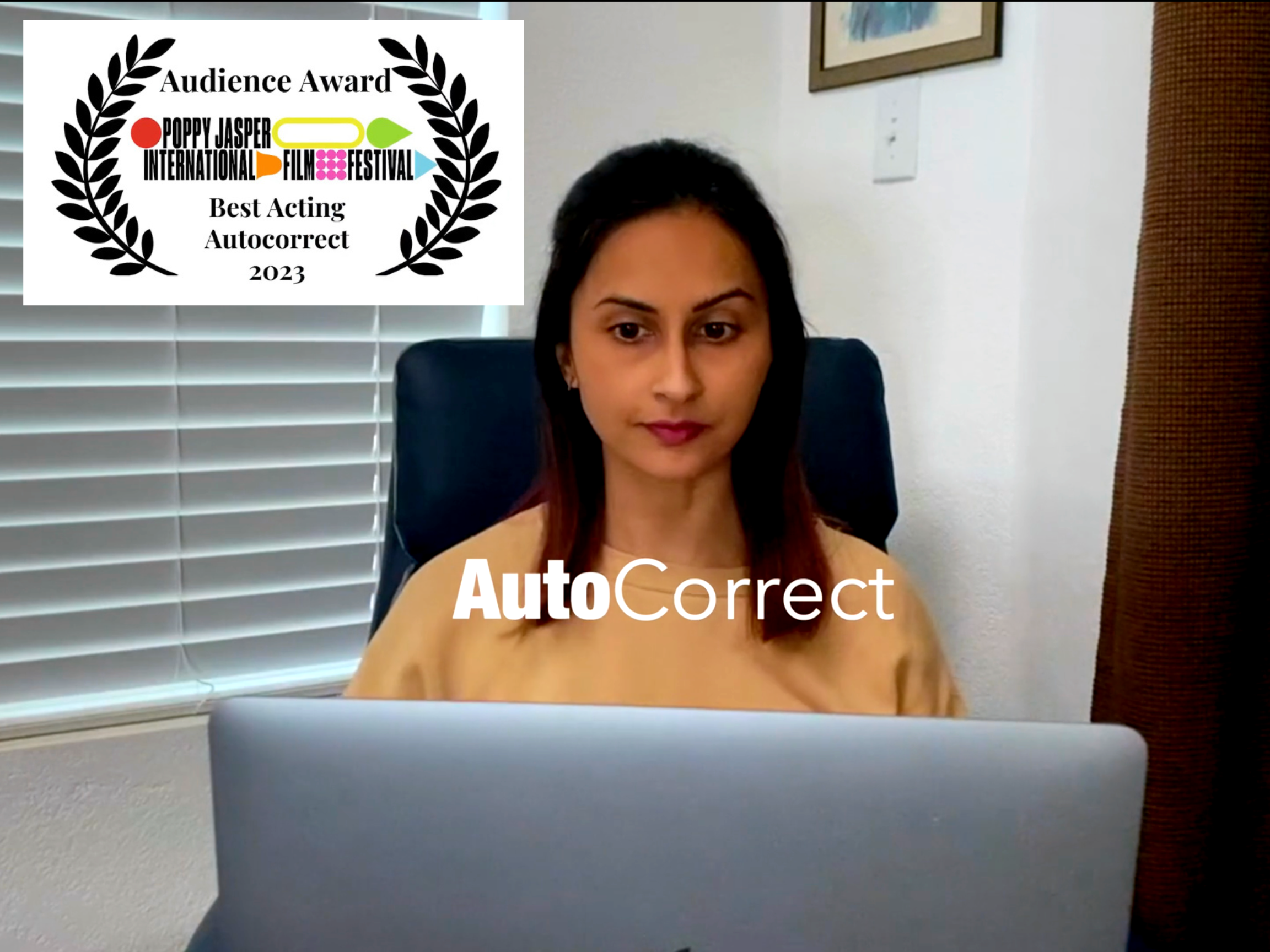 Poster of AutoCorrect film. A young South Asian woman, seated, looks apprehensively at a laptop computer screen. The title AutoCorrect is superimposed over the back of the laptop. Four film festival laurels are featured across the bottom of the poster and one is on the top left.